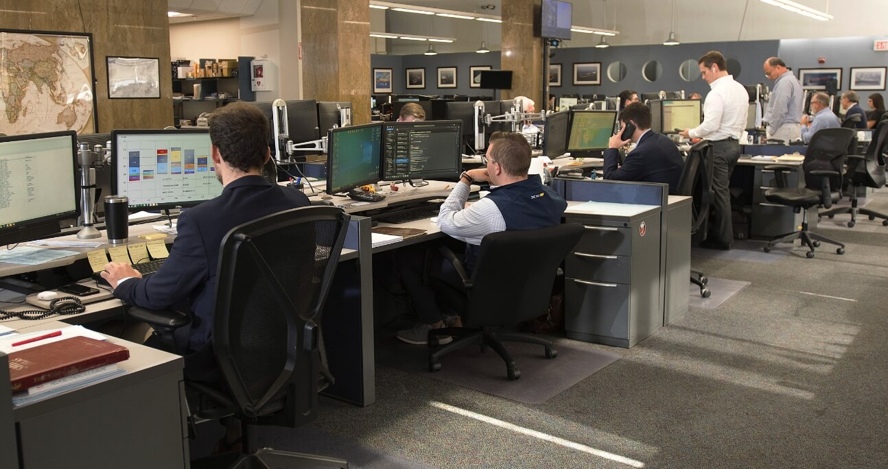 group of employees in an open office using computers