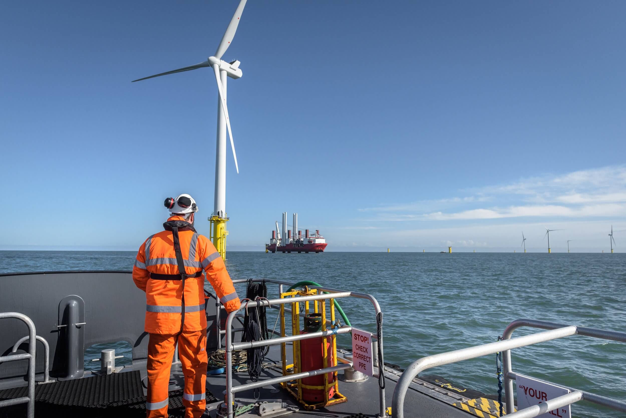 Man on boat deck with wind turbine